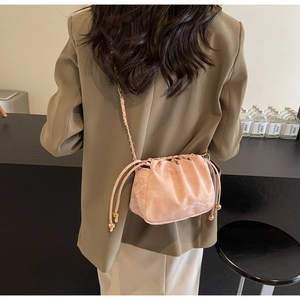 Dettaglio posteriore della borsa a pieghe rosa con tracolla a catena dorata intrecciata