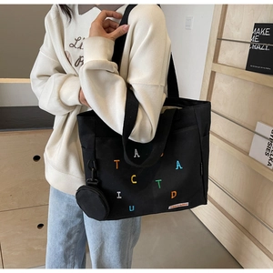 Large black canvas tote bag with colorful embroidery and mini round coin purse pendant