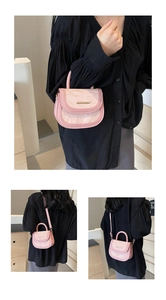 Detailed view of pink pleated texture flap handbag with gold metal clasp on modern background