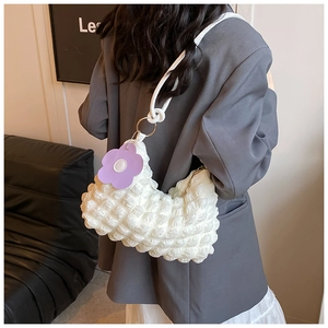 Detail of white puffer cloud bag with textured pleated fabric and flower pendant charm