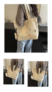 Détail du sac cabas en toile blanc cassé avec imprimé lettres et mini pochette amovible