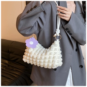 Detail of white bubble pleated shoulder bag with purple flower charm and knotted strap