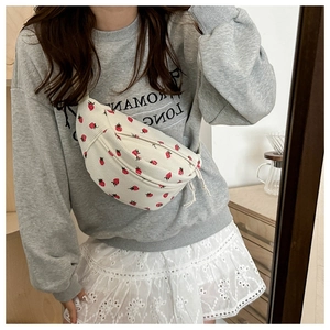 Détail de la texture du sac banane en velours blanc avec motif fraise et double fermeture