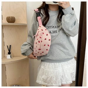 Détail du sac de poitrine en velours rose imprimé fraises avec bandoulière sur modèle