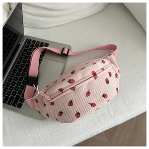 Détail du sac selle en velours rose avec imprimé fraise et bandoulière réglable