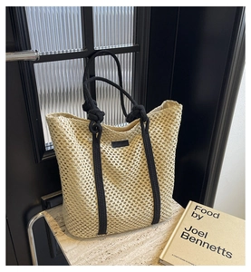 Detalle del bolso de paja trenzada color avena con asas de cuerda negra anudada a mano