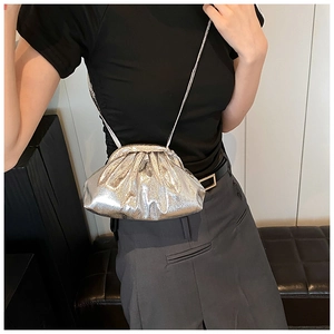 Detail of silver metallic pleated crossbody bag with drawstring and subtle sheen