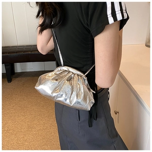 Detail of silver metallic cloud bag with pleated texture and thin shoulder strap