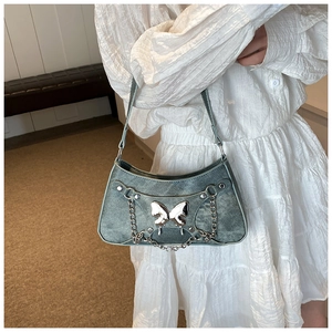 Primer plano del bolso denim vintage con detalle de mariposa de metal plateado