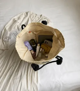 Vista superior del bolso tote de paja calado con interior amplio y asas con nudos