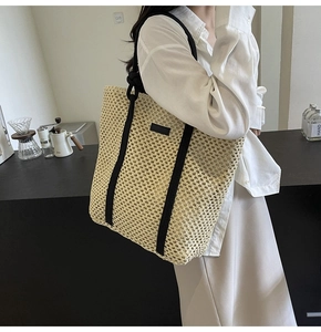 Detalle del bolso tote de paja tejida con correas de lona en contraste y gran diseño