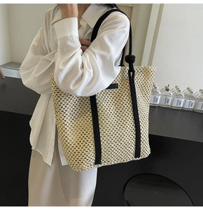 Detalle del bolso tote de tejido calado beige con correas de hombro de cuerda negra