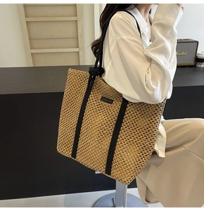 Detalle de bolso tote de paja tejida a mano con correas de cuerda negra en modelo