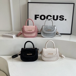 Minimalist saddle bags in pink, silver, black, and beige colors on a tiered display