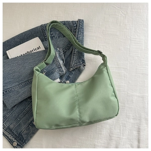 Detail of mint green hobo bag showing fabric texture, vertical seams and silver hardware