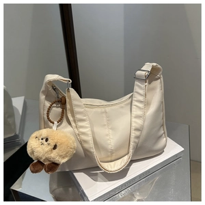 Detail of off-white crescent oxford fabric shoulder bag with cute brown plush charm