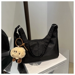 Minimalist black nylon crescent hobo bag with adjustable strap and cute plush quokka charm