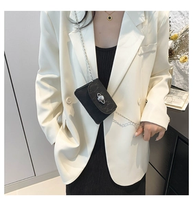 Detailed view of mini black crossbody bag with silver planet logo and metal chain strap