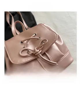 Detail des rosa PU-Lederrucksacks mit Kordelzug, Schleife und Perlendekoration