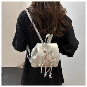 Silberner Mini-Rucksack mit rosa Schnürschleifen und dekorativen Perlenakzenten