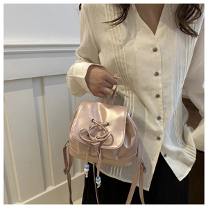 Nahaufnahme des rosa Metallic-Rucksacks mit Kordelzug und dekorativem Schleifendetail