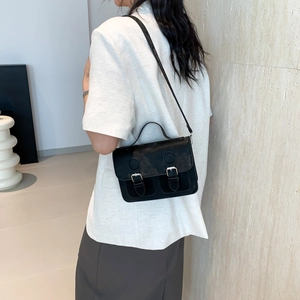 Classic black Cambridge messenger bag with silver buckles shown on model for daily styling