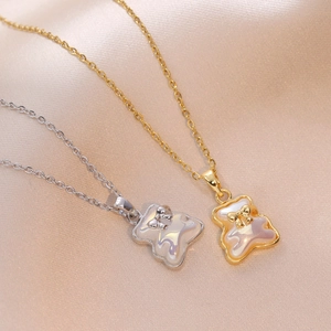 Schattige hanger ketting in beer-vorm in goud en zilver op elegante satijnen stof