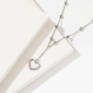 Minimalist stainless steel Y-shaped heart pendant necklace with beaded chain on stone