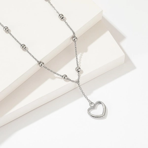 Titanium steel silver beaded necklace featuring a hollow heart pendant on geometric blocks