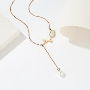 Collana a tulipano oro rosa con intarsio in madreperla e nappa di perle su fondo bianco