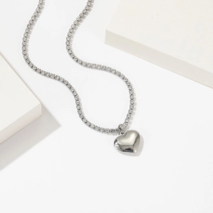 Silver titanium heart necklace with sparkling zircon pavé chain on white background