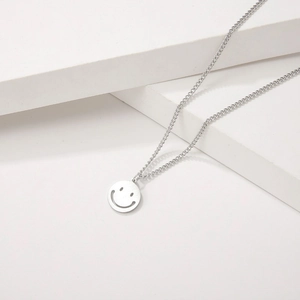Minimalist titanium steel necklace featuring a hollow smiley face pendant on a chain