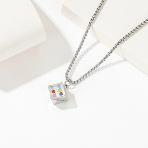 Collana in acciaio al titanio retrò con ciondolo a dado colorato su supporto bianco