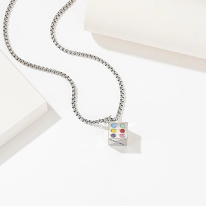 Collana in acciaio al titanio con ciondolo a cubo colorato su sfondo bianco moderno