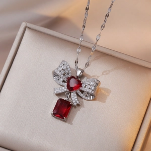 Elegant silver necklace with red heart bow and rectangular crystal pendant in jewelry box