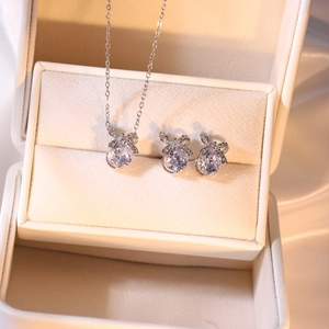 Detail von Schleifen-Halskette und Ohrringen mit Zirkonia-Steinen in einer Geschenkbox