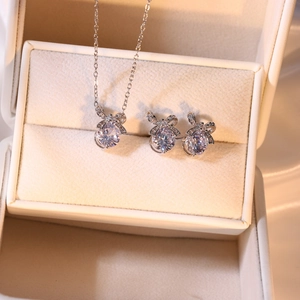 Detailansicht des silbernen Schleifen-Zirkonia-Schmucksets mit Halskette und Ohrringen