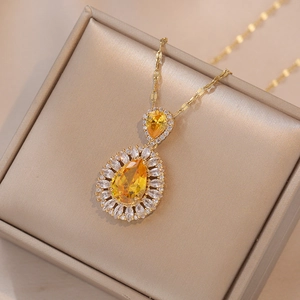 Élégant collier doré avec pierre précieuse jaune poire et halo de zircons marquises