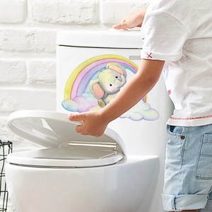 Detail of cartoon elephant on rainbow sticker applied to a white toilet tank in bathroom