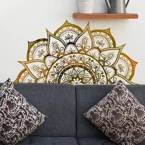 Mandala wall sticker set in gold gradient above a cozy bohemian style living room sofa