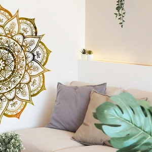 Detail of a large gold mandala wall sticker styled in a cozy bohemian living room setting