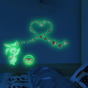 Luminous wall decals featuring cartoon bunny and pink hearts glowing in a dark kid's bedroom