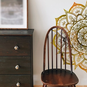 Detailed golden mandala wall decal applied on a white wall in a bohemian living room