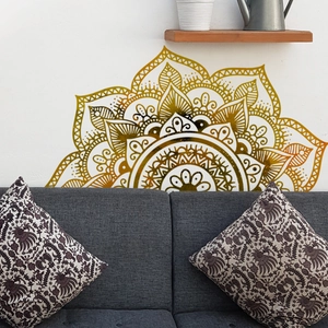 Detailed golden mandala wall decal positioned above a grey sofa for home decor
