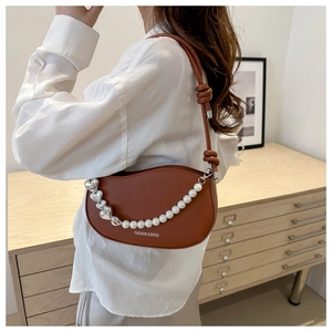 Brown semi-circular saddle bag detail featuring heart chain and pearl accents