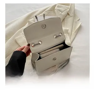 Internal capacity of the white flap bag showing space for phone and small wallet