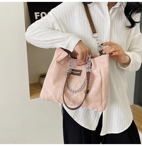 Détail du sac cabas rose clair, texture plissée, lanières en cuir marron et chaîne argent