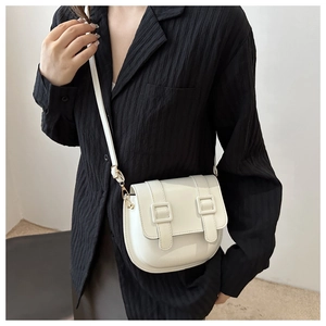 Detail of white PU leather saddle bag with double strap decor and adjustable strap