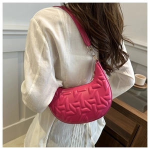 Detail view of hot pink crescent bag featuring 3D geometric texture and gold hardware