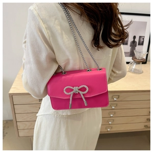 Sac bandoulière fuchsia chic avec un nœud en strass argentés et chaîne en métal